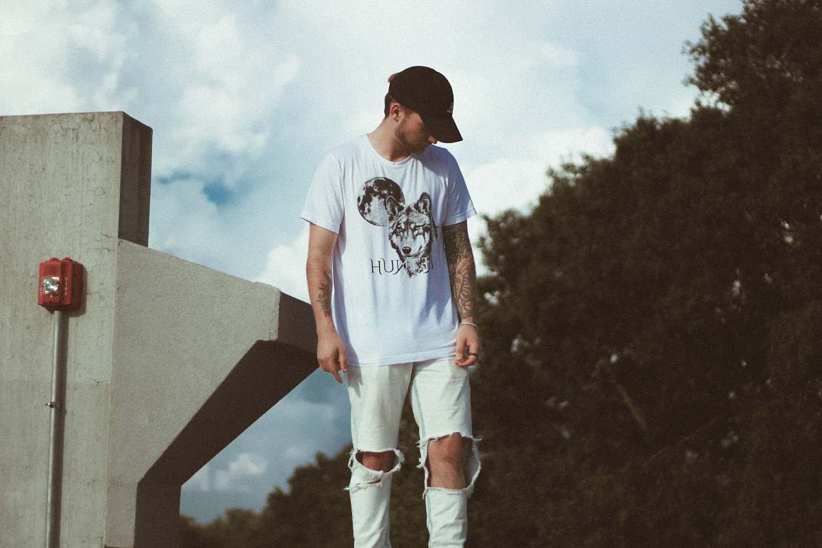 people man stands near gray concrete post during daytime person