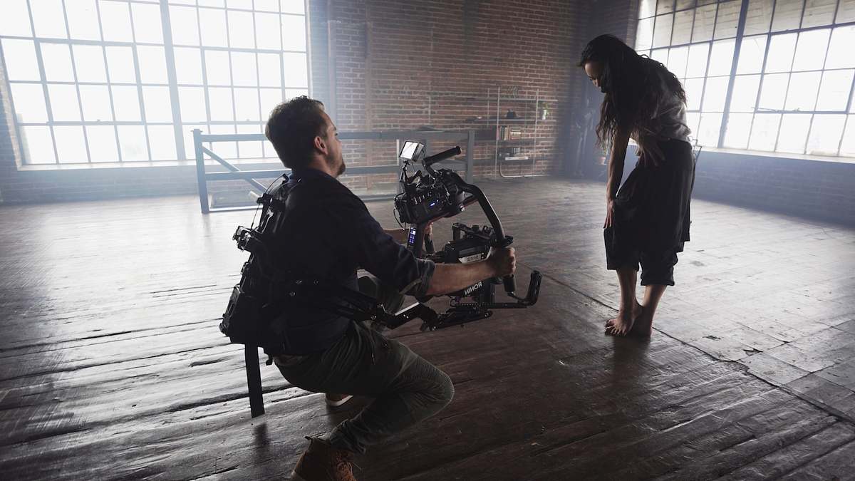 people man taking video with woman standing inside room person