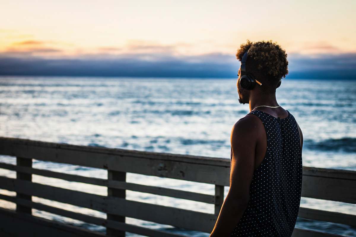 person man walking on dock facing ocean people