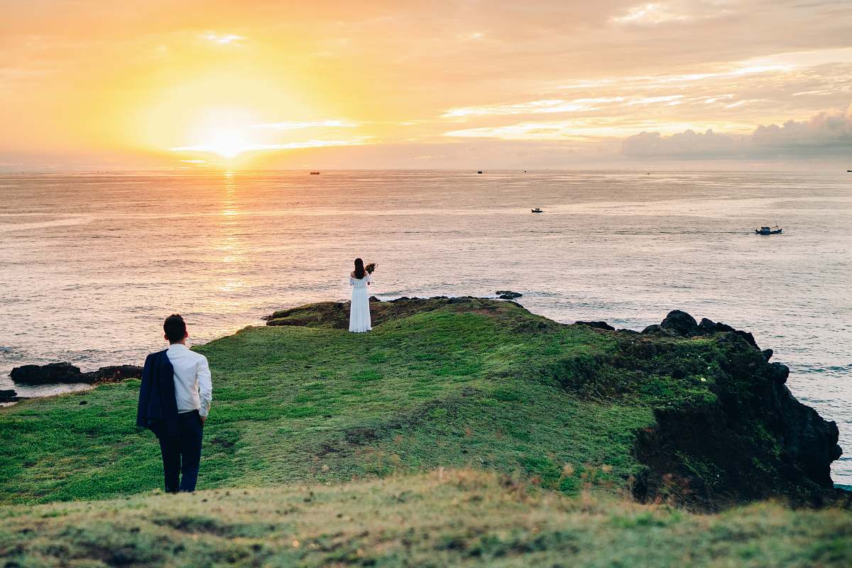 people man walking towards woman standing on cliff person