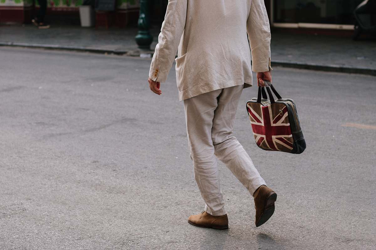 people man walking while holding handbag person