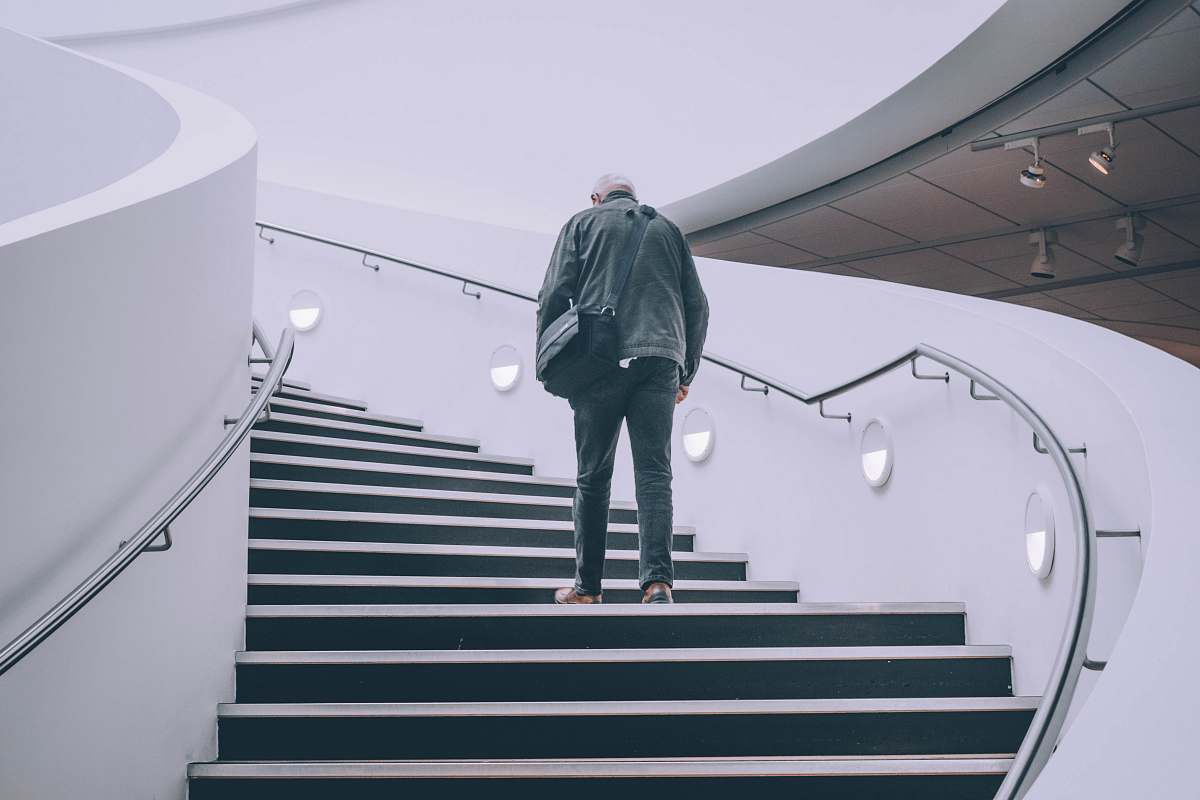 people man wearing black jacket standing on black concrete stairs person