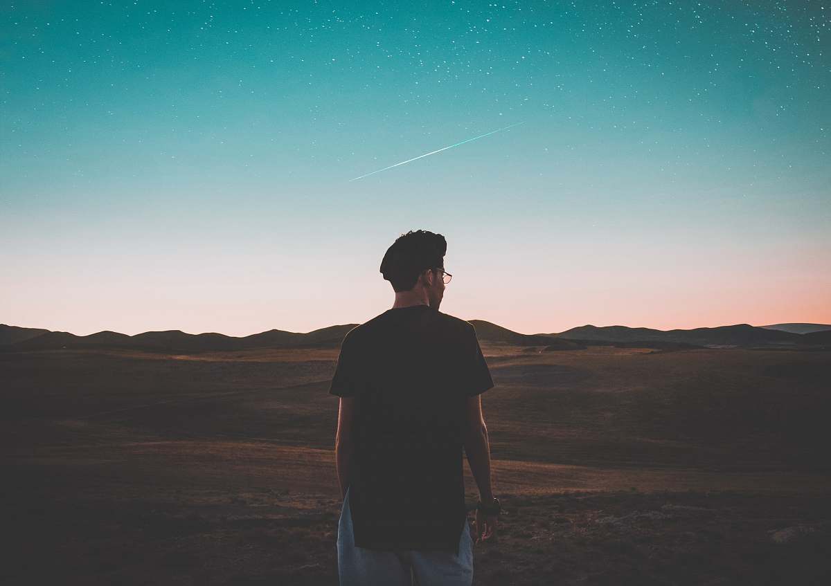 person man wearing black top standing in front of mountain people