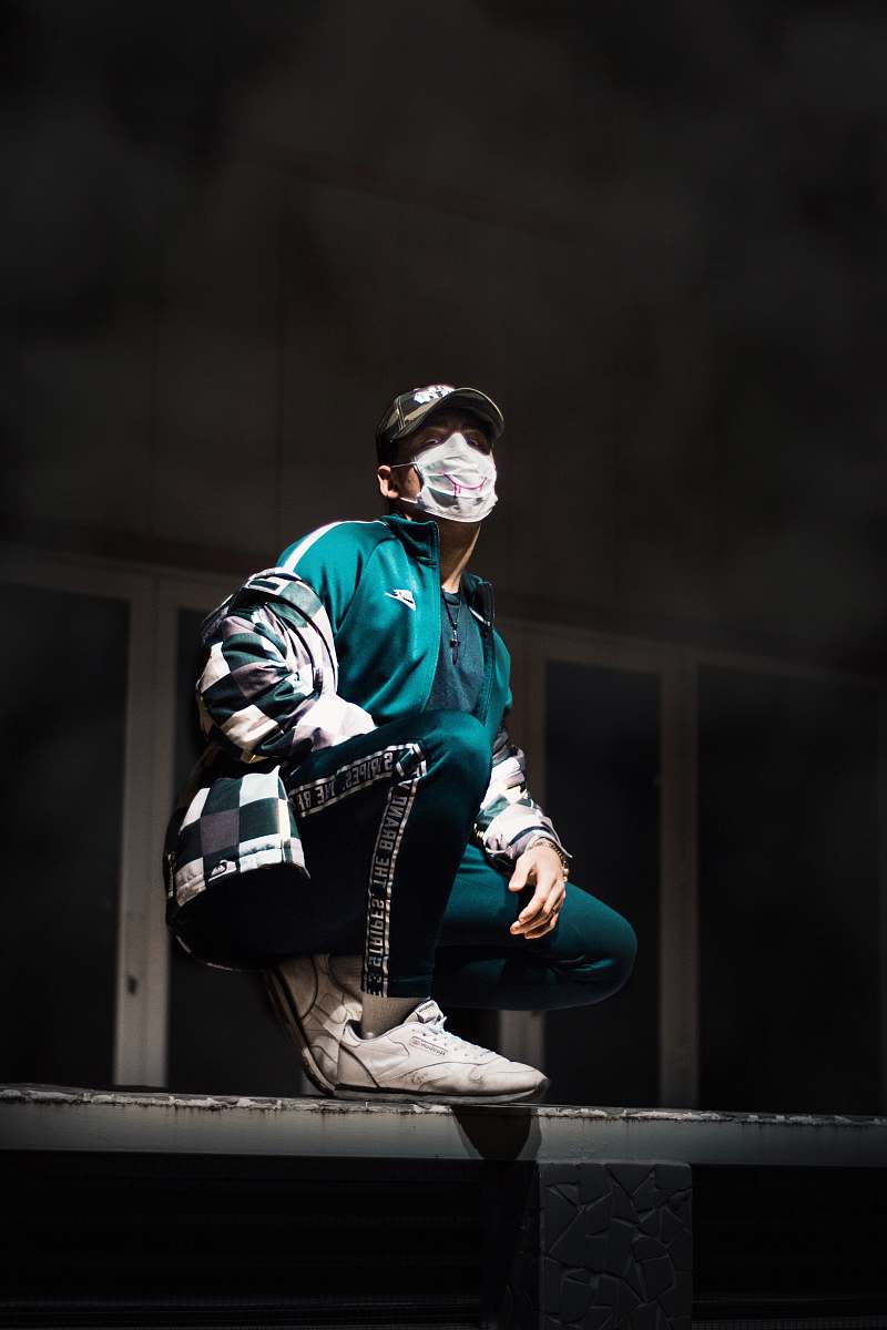 person man wearing face mask crouching on wall people