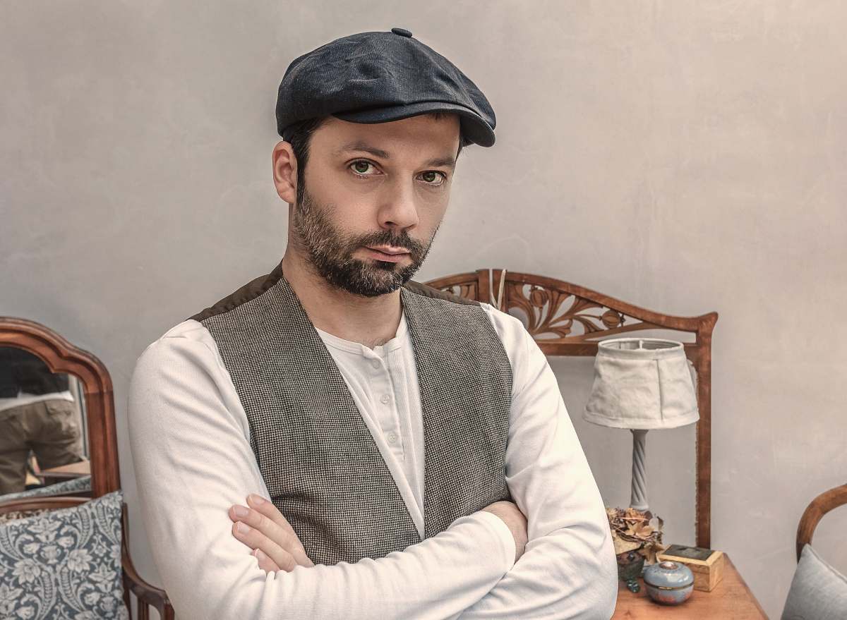 people man wearing gray vest near white table lamp person