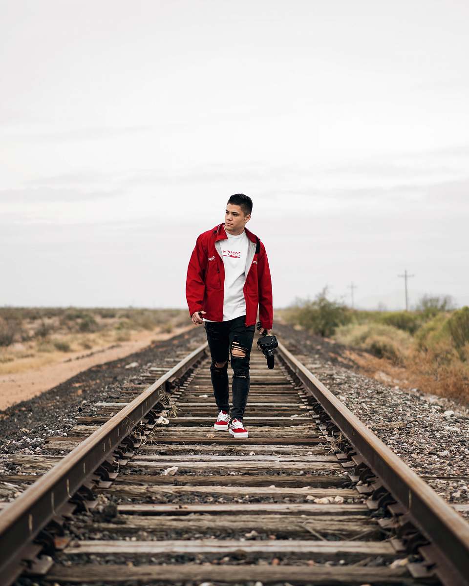 people man wearing jacket waking on train rail person