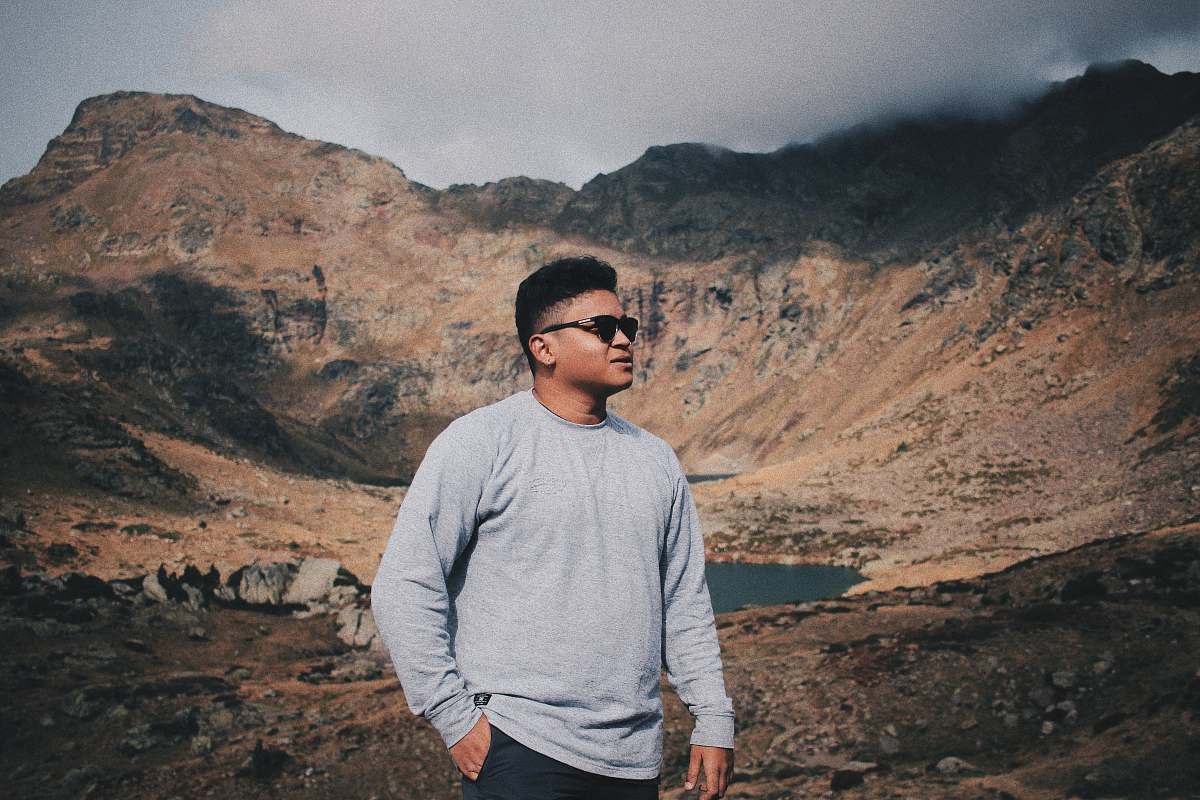 people man wearing sweater and sunglasses with mountain background person