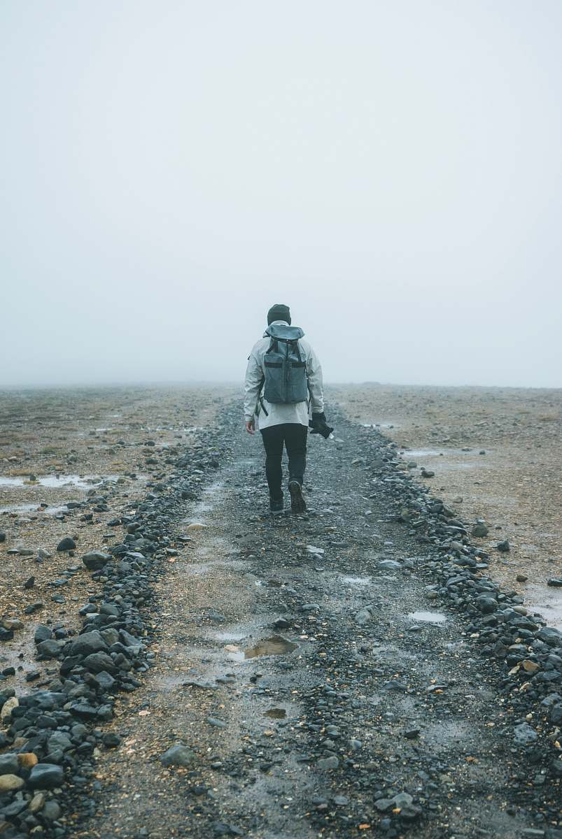 people man with backpack walking on brown field person