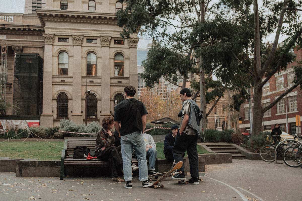 people people on bench near brown building person