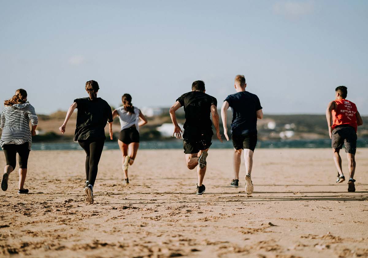 people people running on seashore person