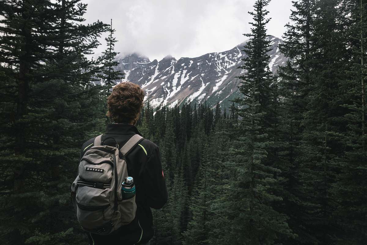 person person carrying bag looking toward glacier mountain at daytime backpack