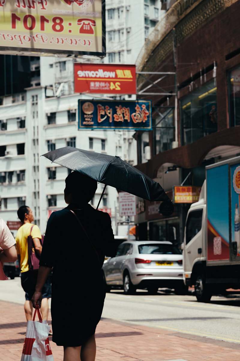 people person holding umbrella walking on street person