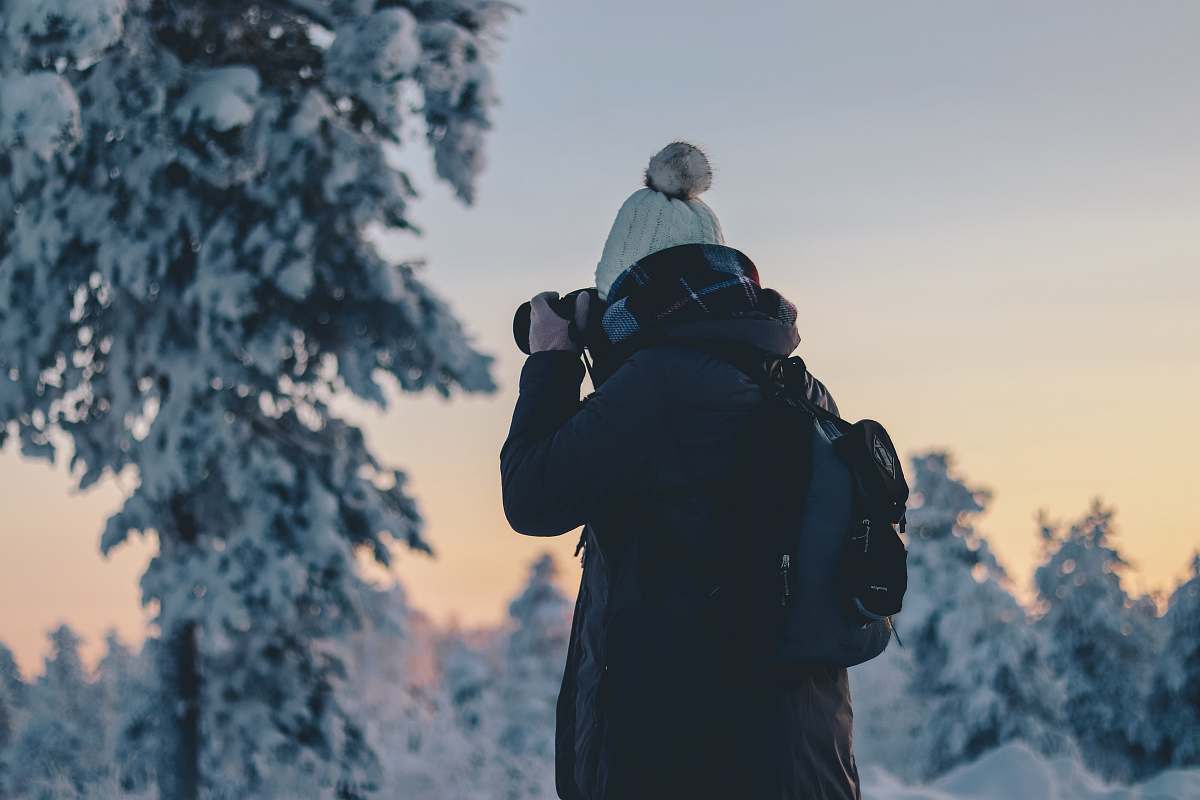 people person in black winter jacket holding black DSLR camera during daytime person