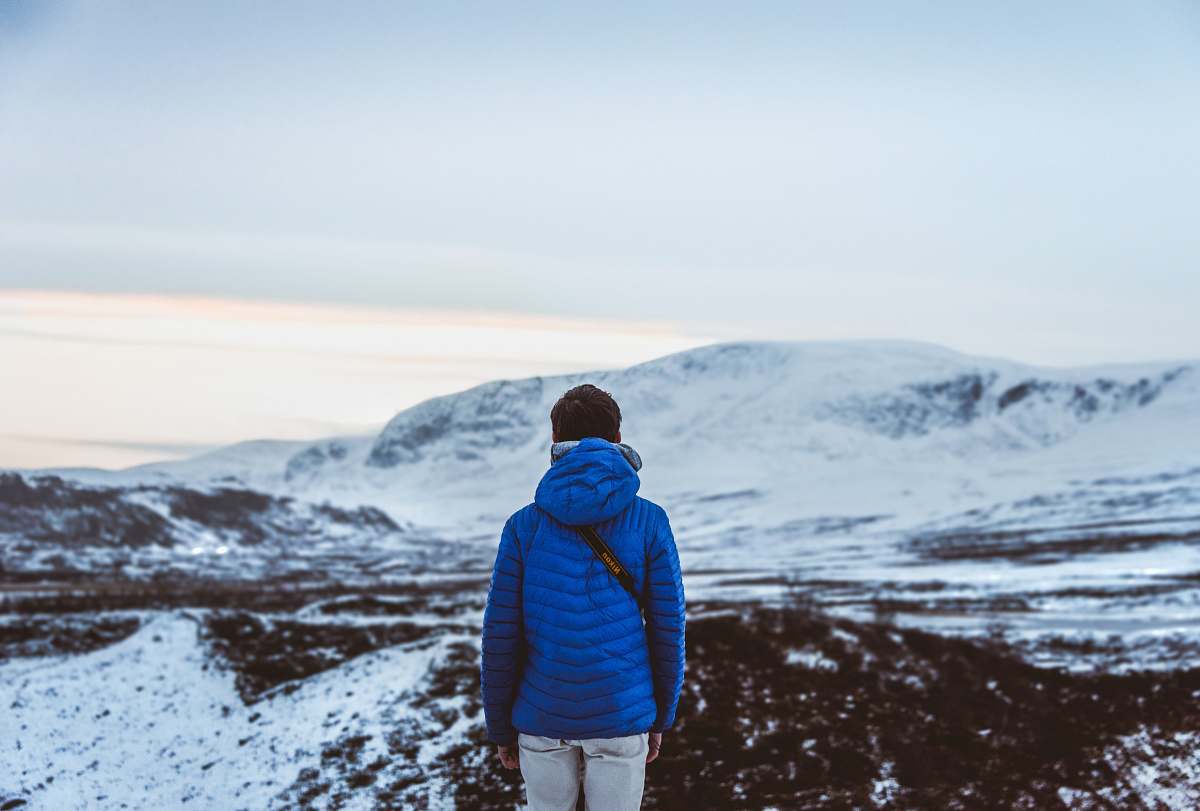 people person in blue hoodie facing snow covered hill person