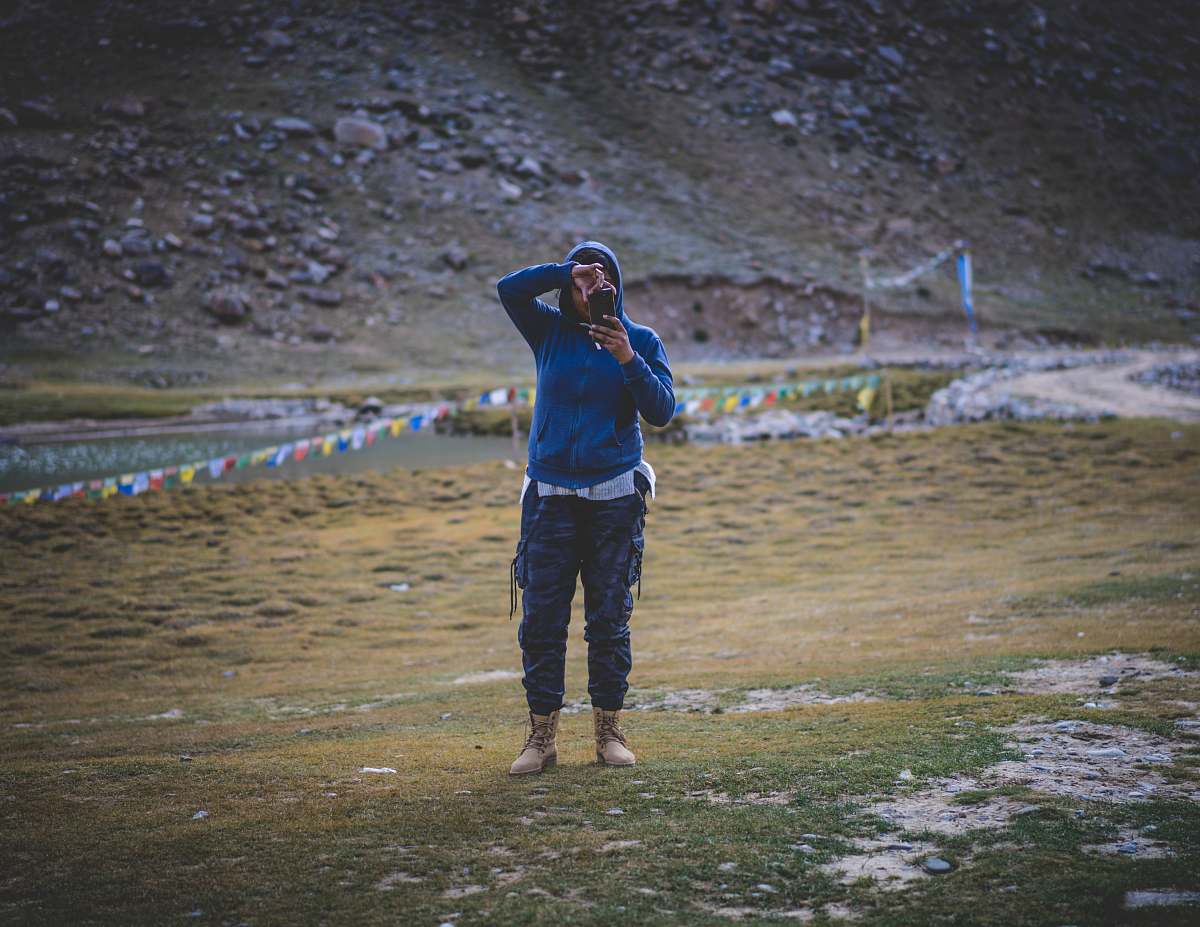 people person in blue jacket and pants holding phone taking picture person