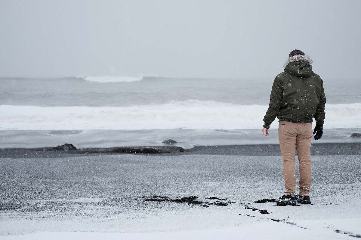 people person in grey jacket and brown standing standing at the shore person