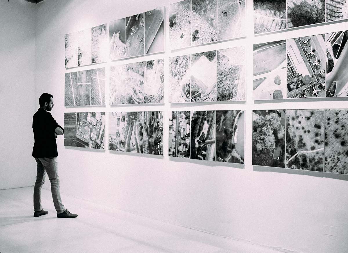 person person looking at gallery art pieces on wall people