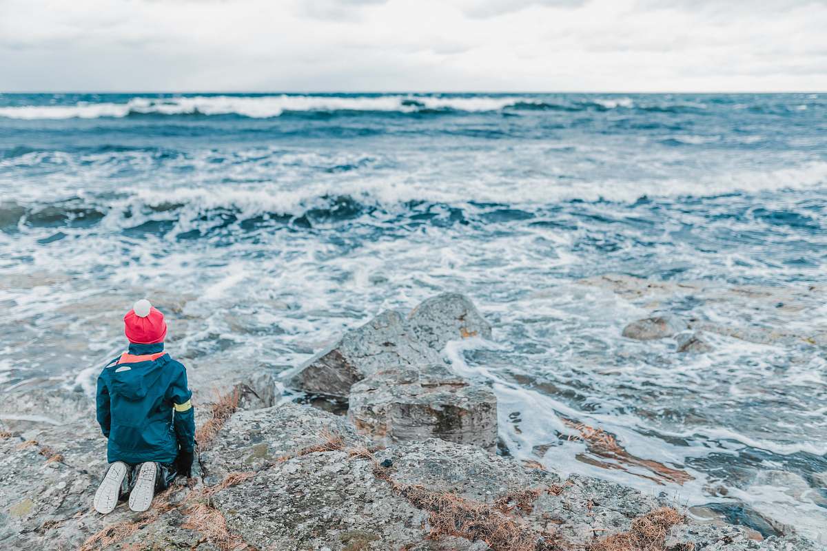 people person on hilltop staring at body of water child
