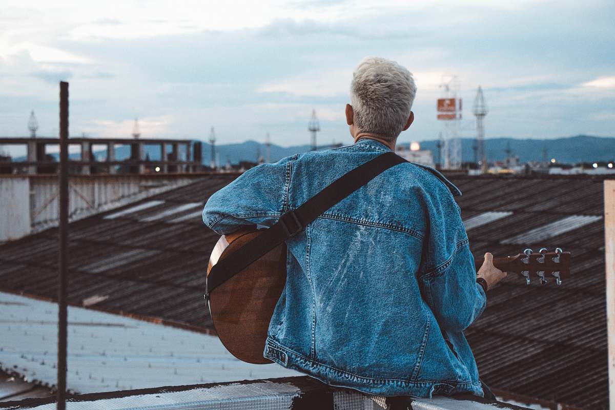person person playing guitar on rooftop people