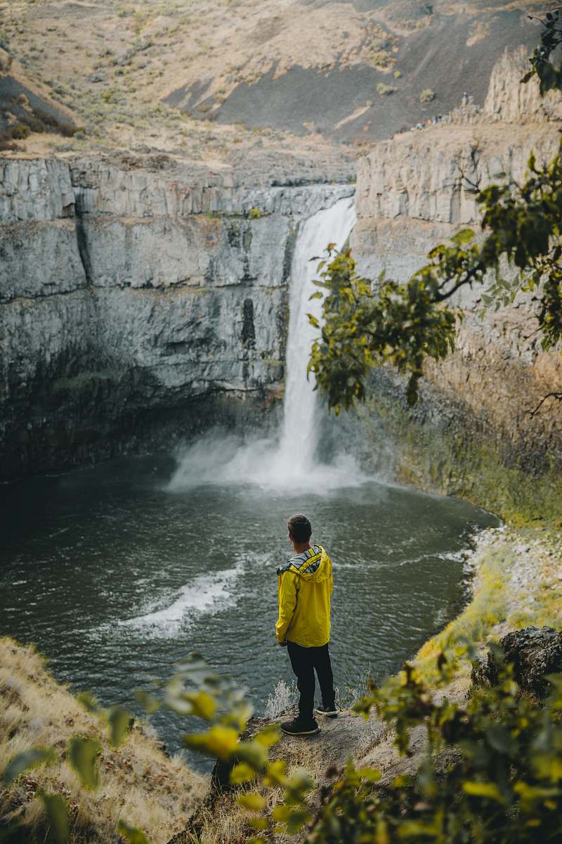 people person standing near waterfall during daytime person