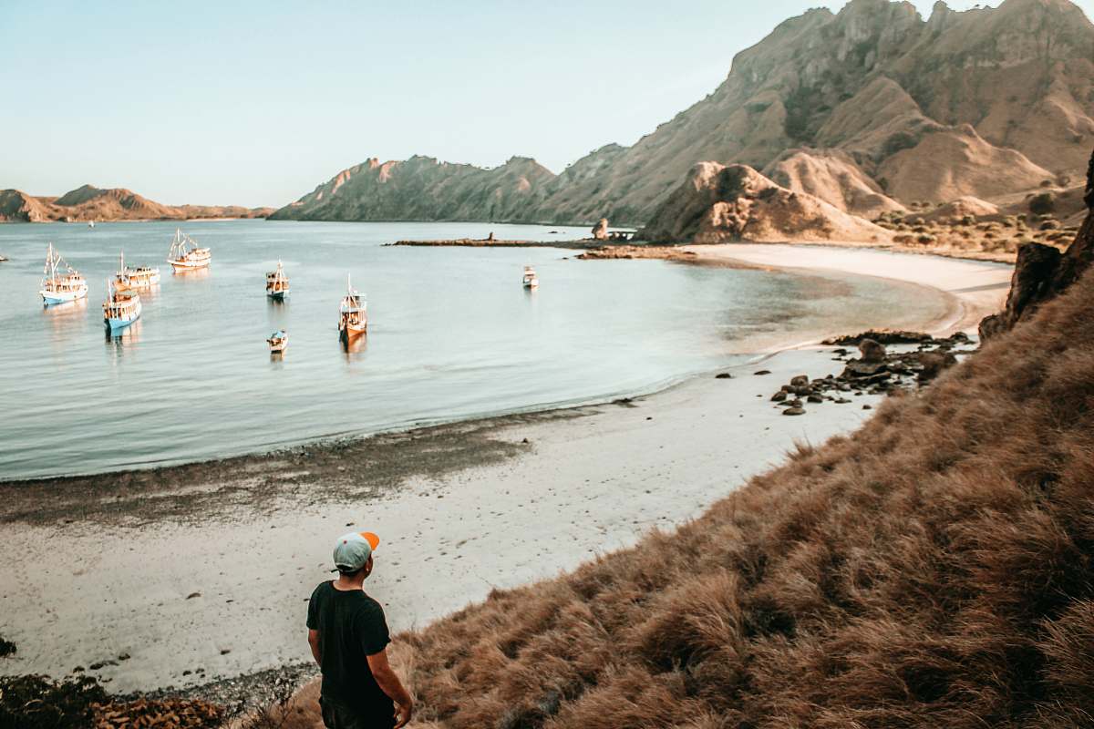 people person standing on shore near boats during daytime person