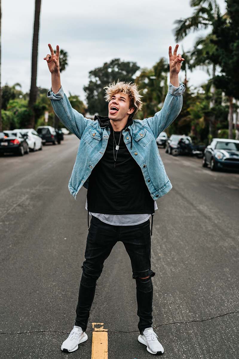 person person standing on street raising peace sign car