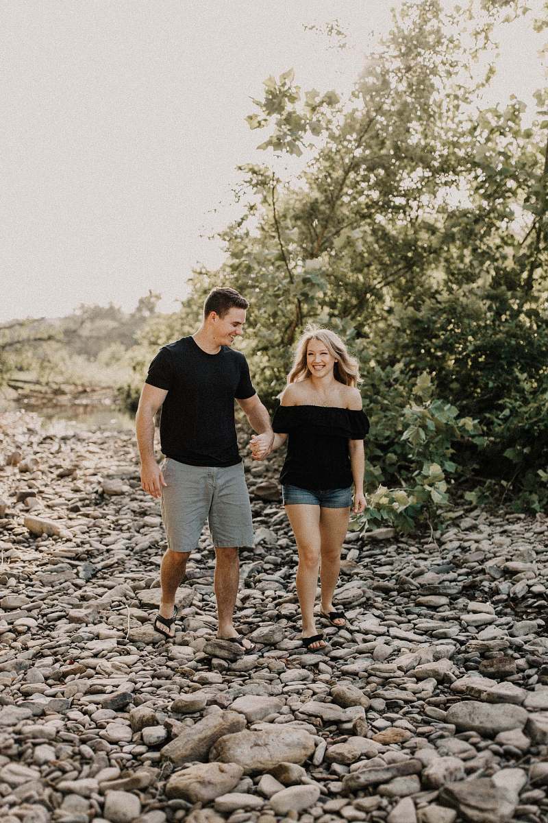 people photo of man holding woman's hand while walking person