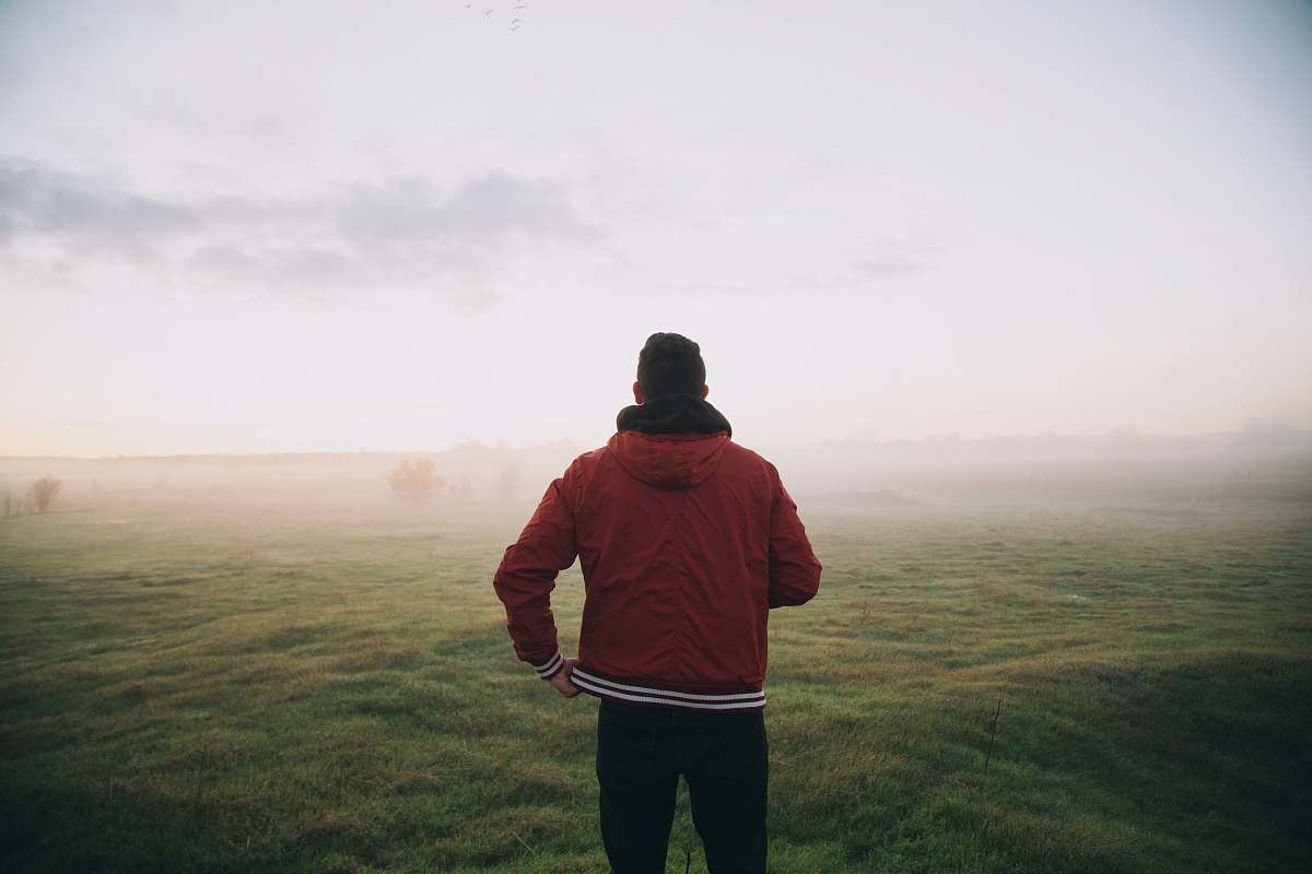 people photo of man wearing red jacket facing horizon person