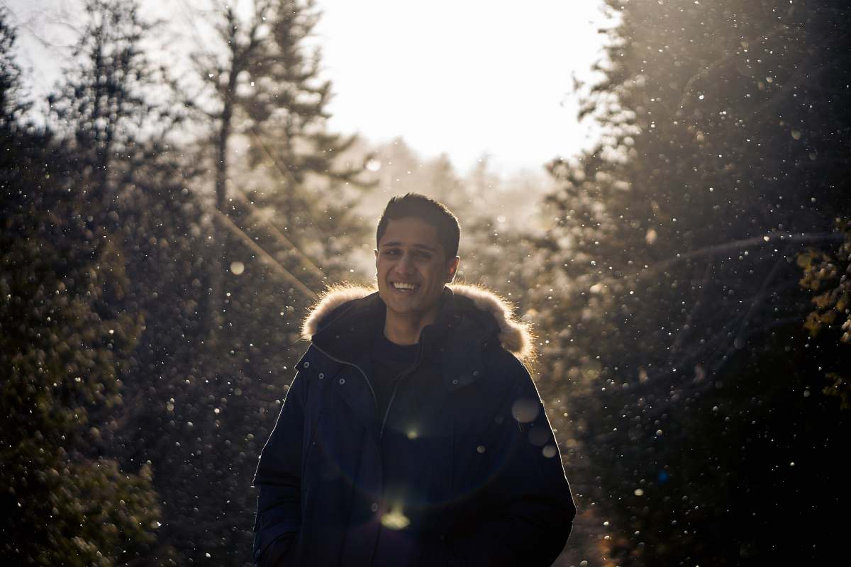 person selective focus photo of man standing between pine trees people