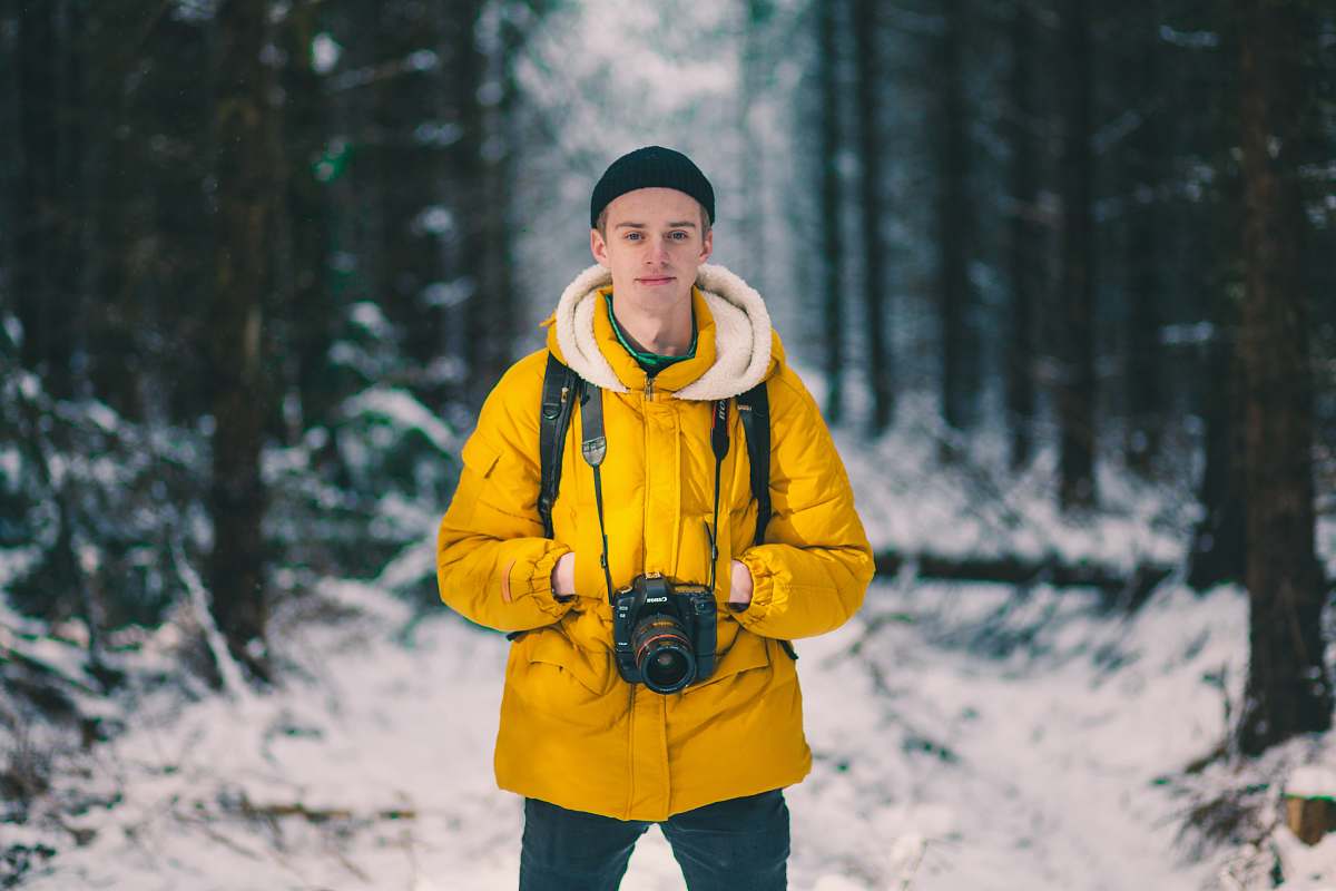 people selective focus photo of man standing holding DSLR camera person