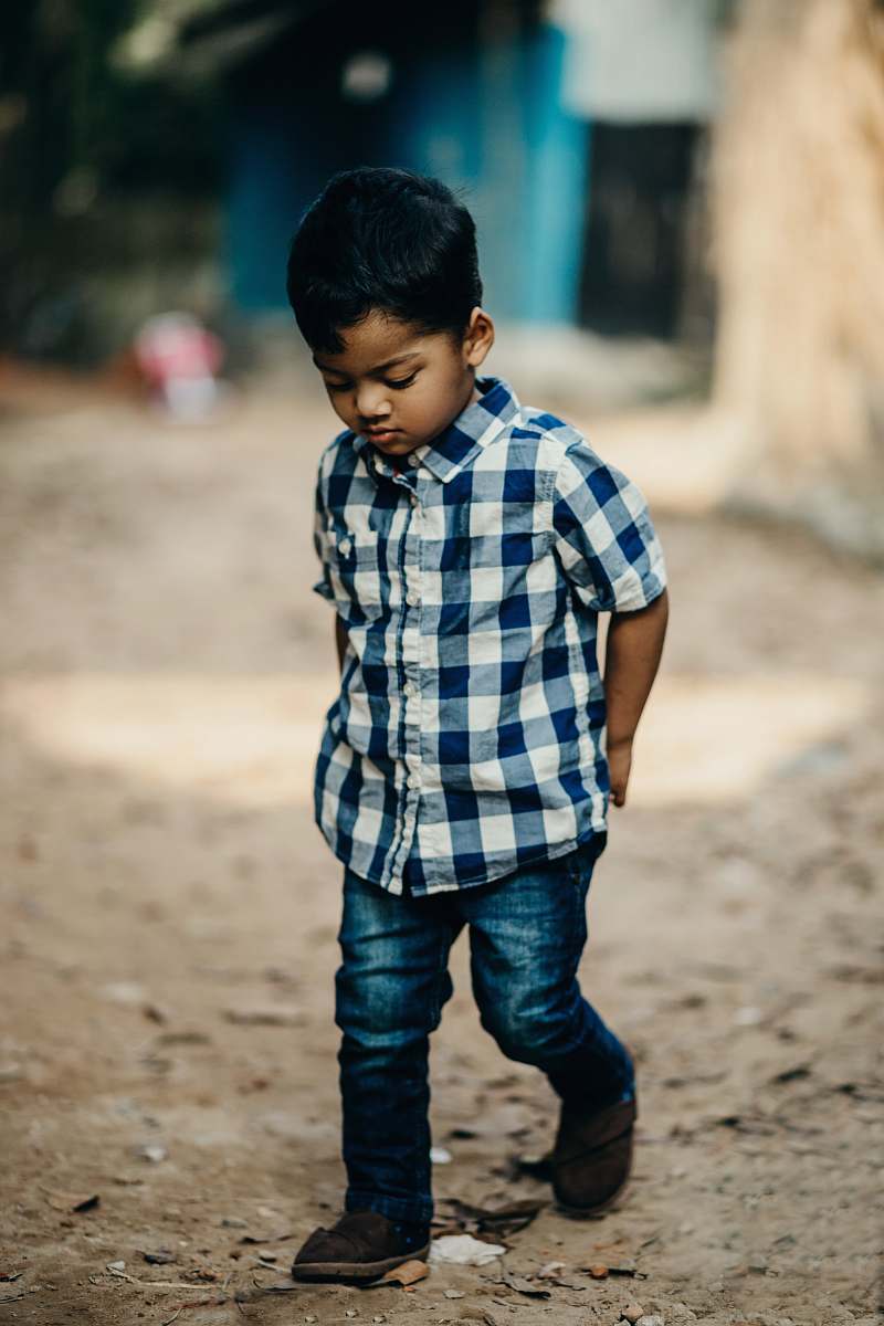 people selective focus photography of boy in blue and white checked button-up shirt looking down person