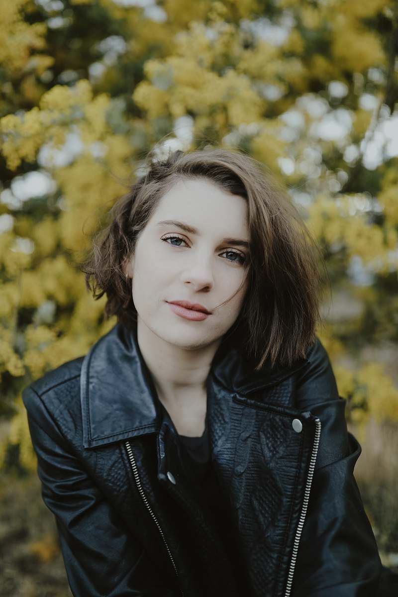 people selective focus photography of woman wearing black leather zip-up jacket person