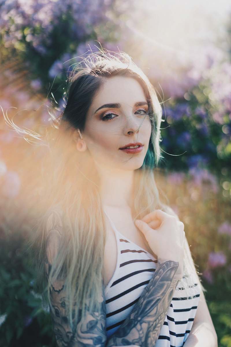 person selective focus photography of woman wearing white and black striped spaghetti strap top people