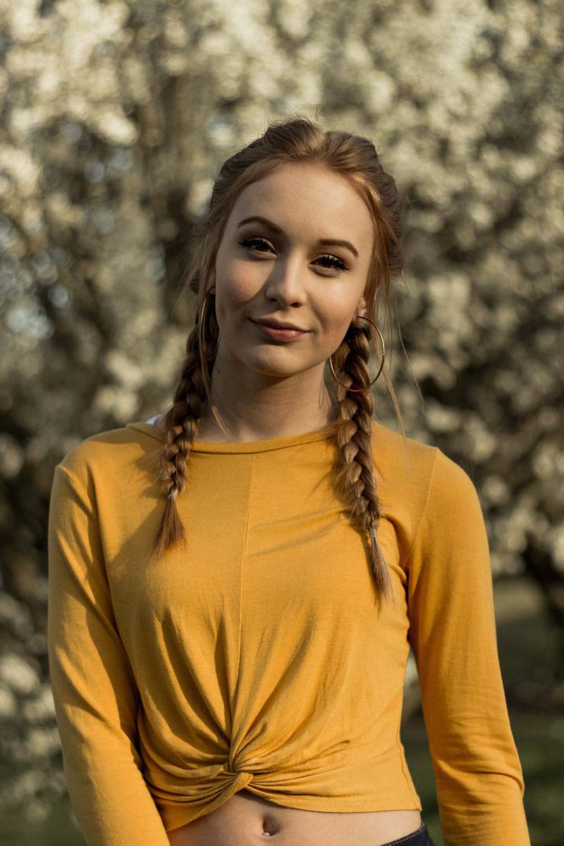 people selective focus photography of woman wearing yellow scoop-neck long-sleeved crop top person