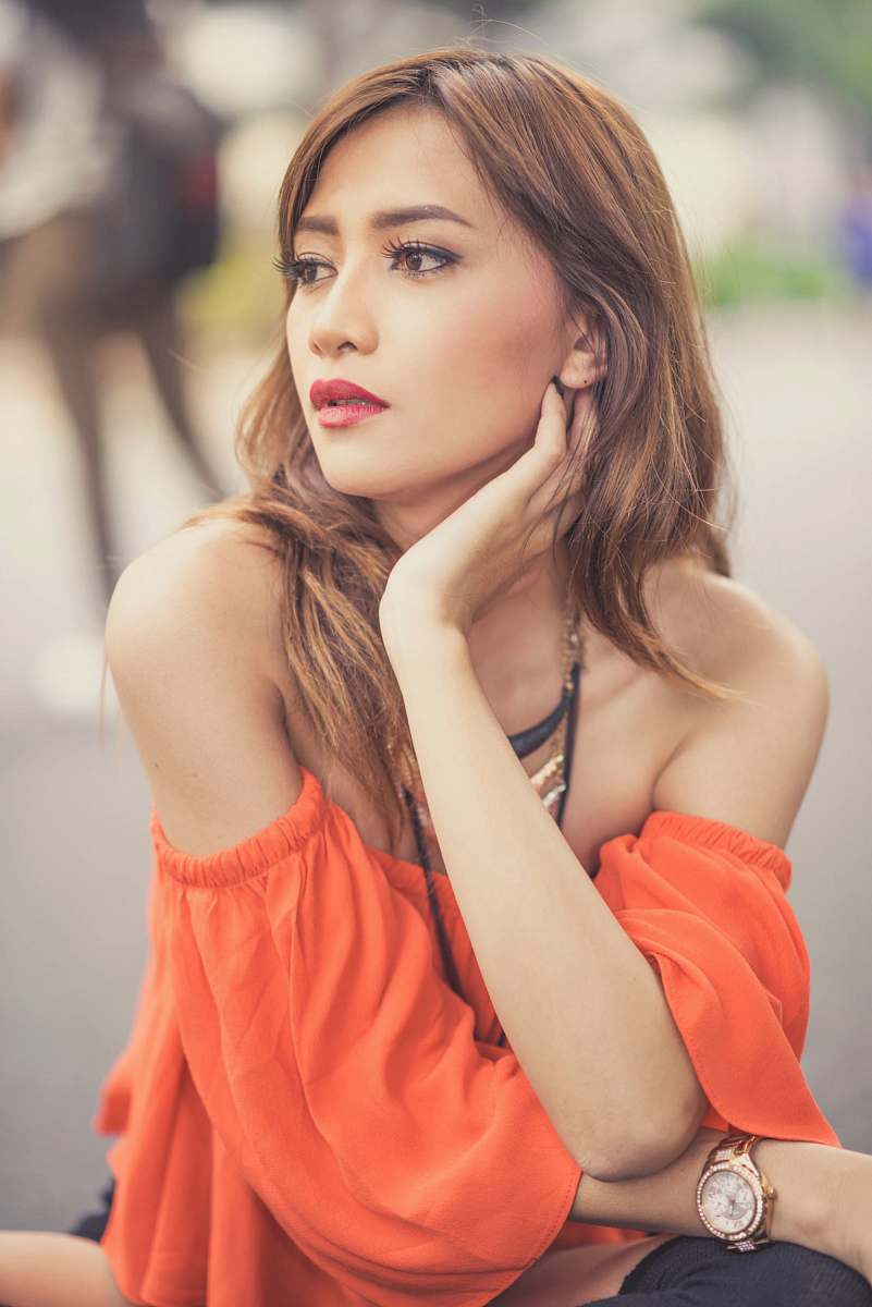 people shallow focus photo of woman holding her neck person