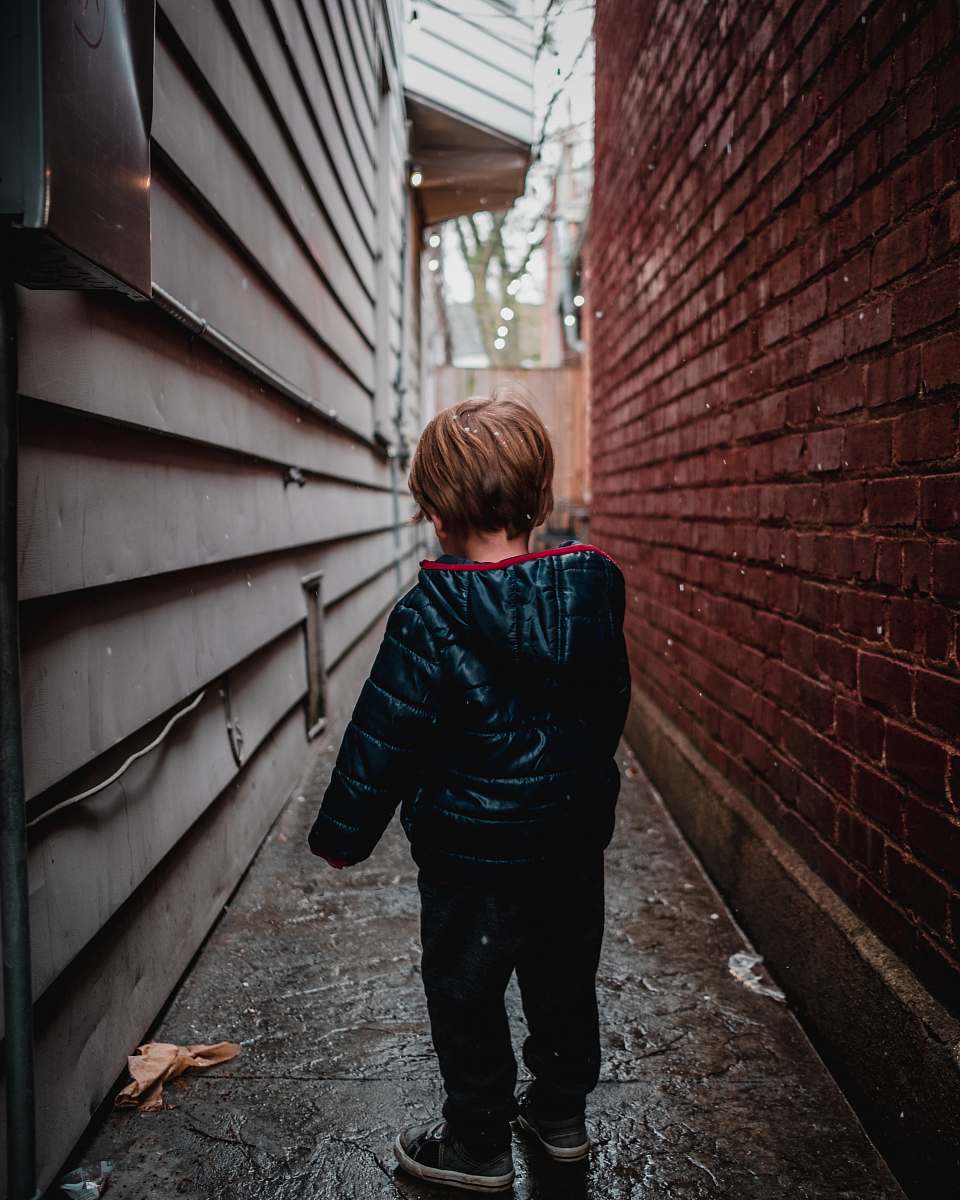 people shallow focus photography of toddler in alley person