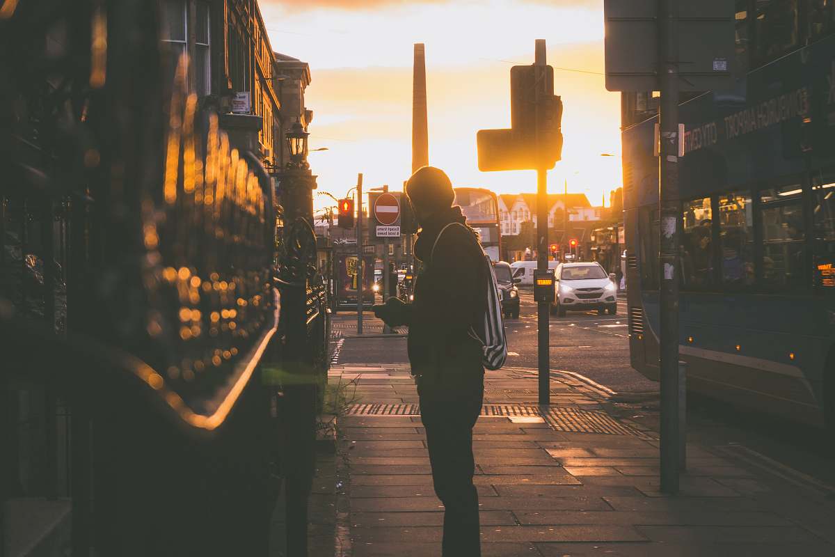 people silhouette photography of man standing in front of building person