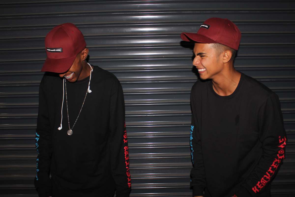 people smiling two men standing front of door shutter person