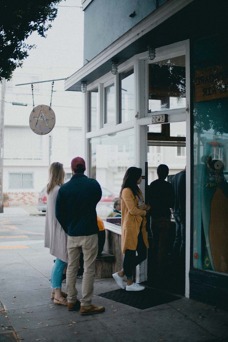 people three people standing near glass door person
