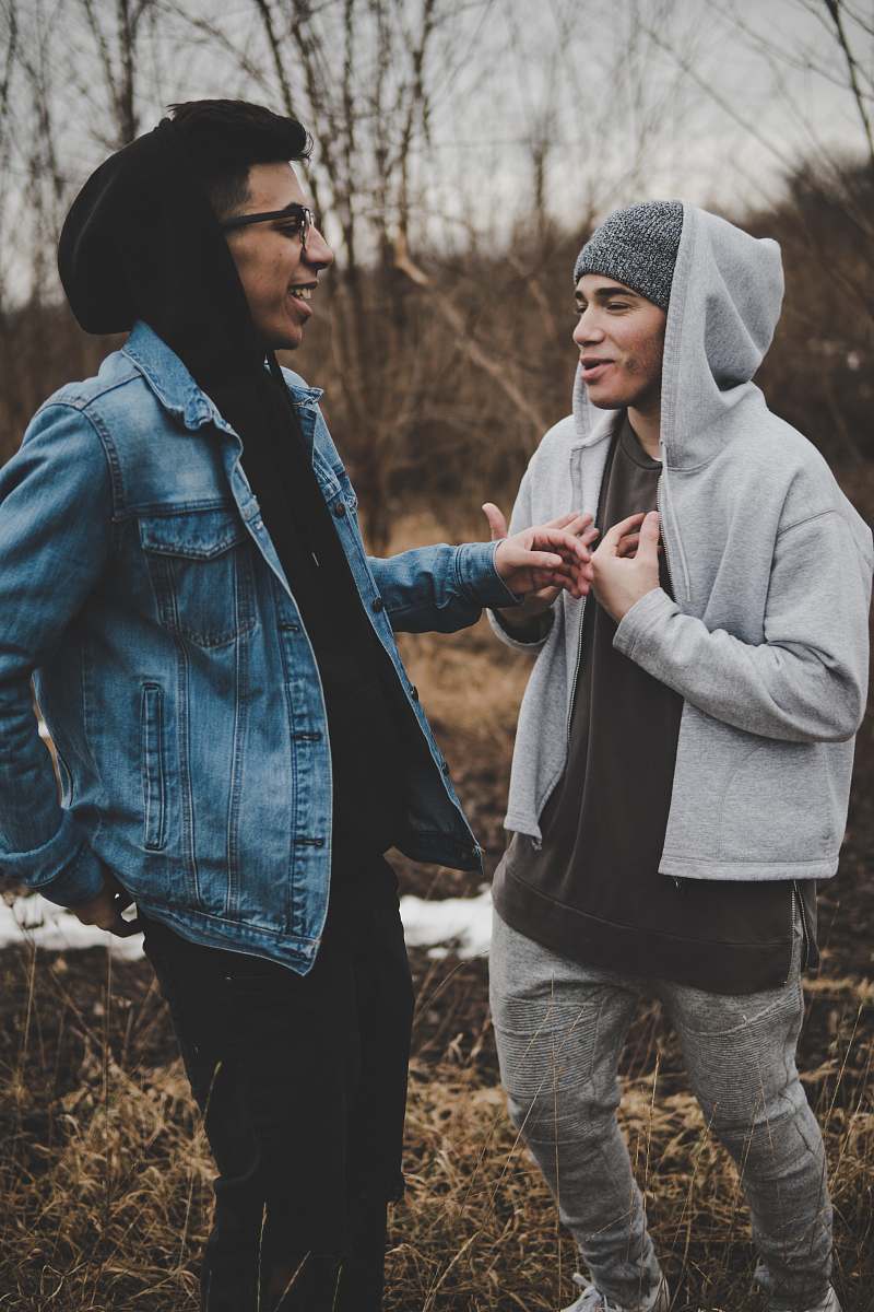 people two man talking while laughing on brown grass person