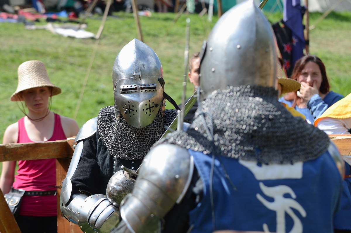 people two men wearing silver armor facing each other person