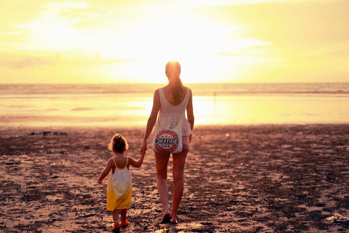 people woman and child facing towards sunset person