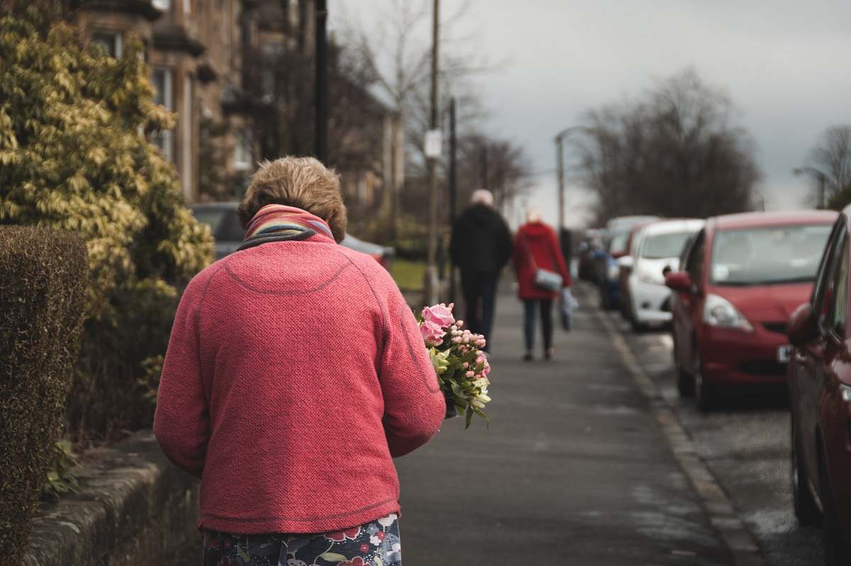 people woman carrying bouquet of flower white walking on street person