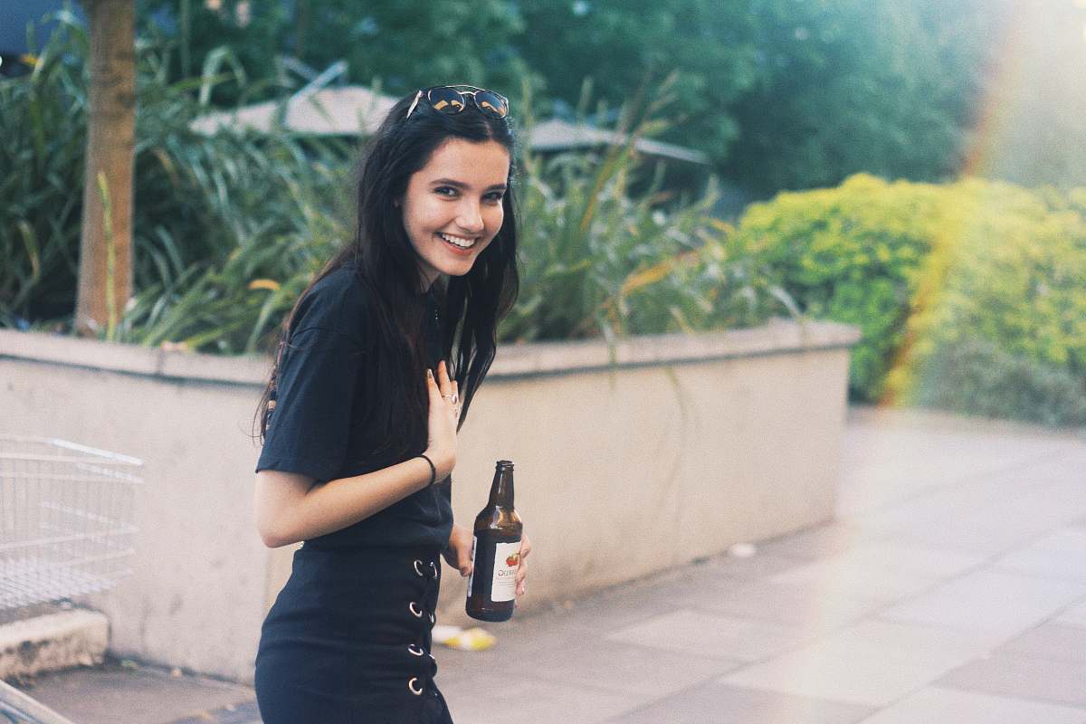 person woman holding black bottle in rule of thirds photography people