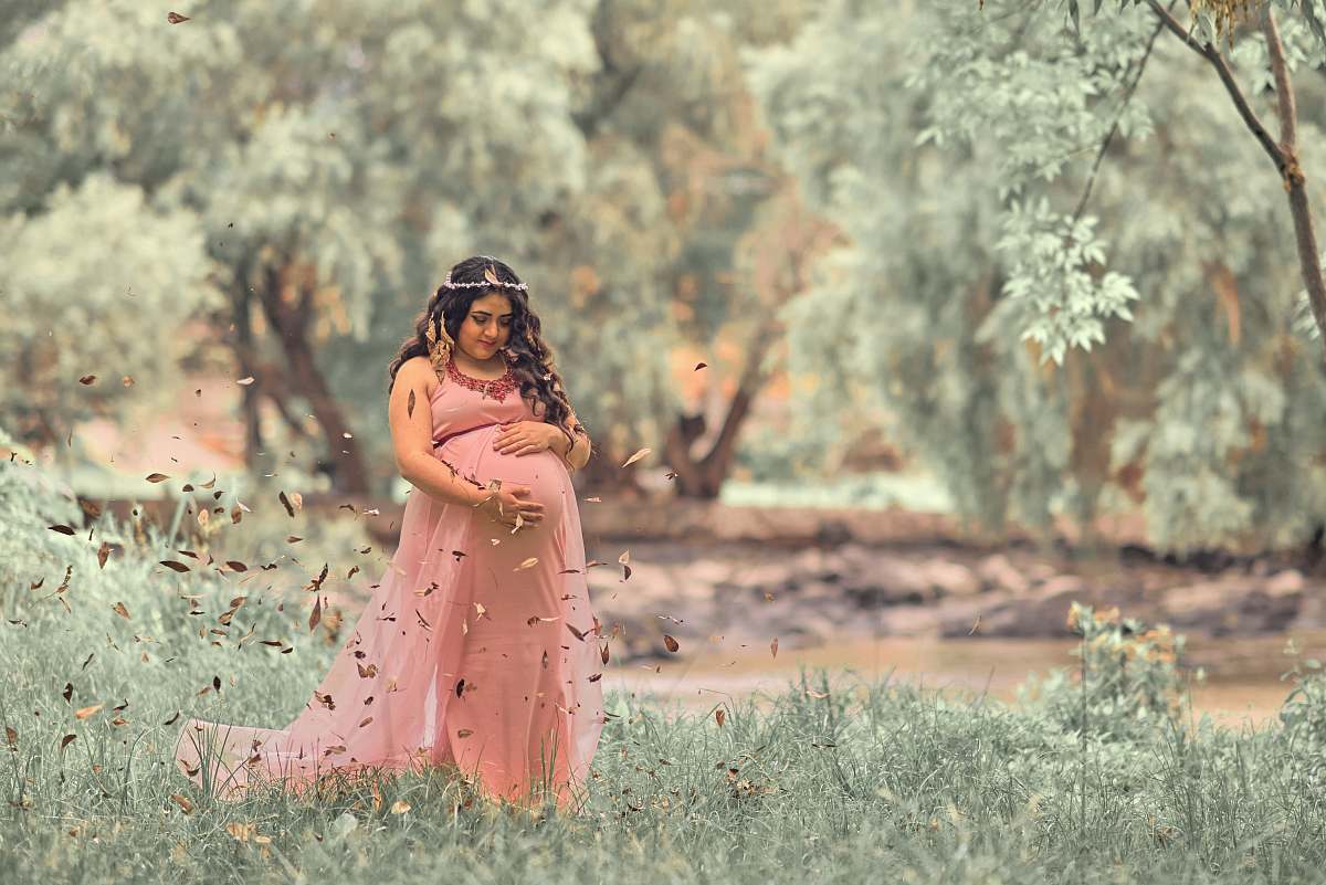 people woman holding her pregnant tummy near tree person