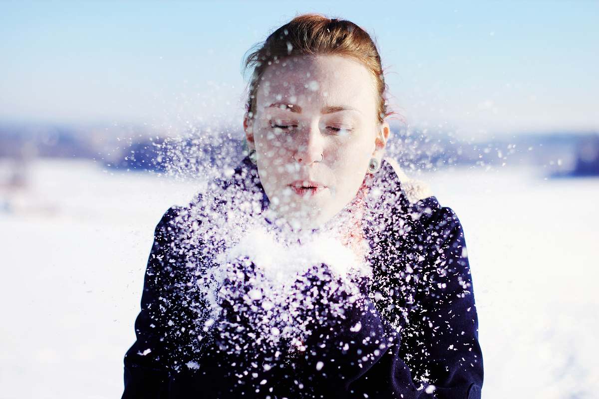 people woman in black jacket blowing snow person