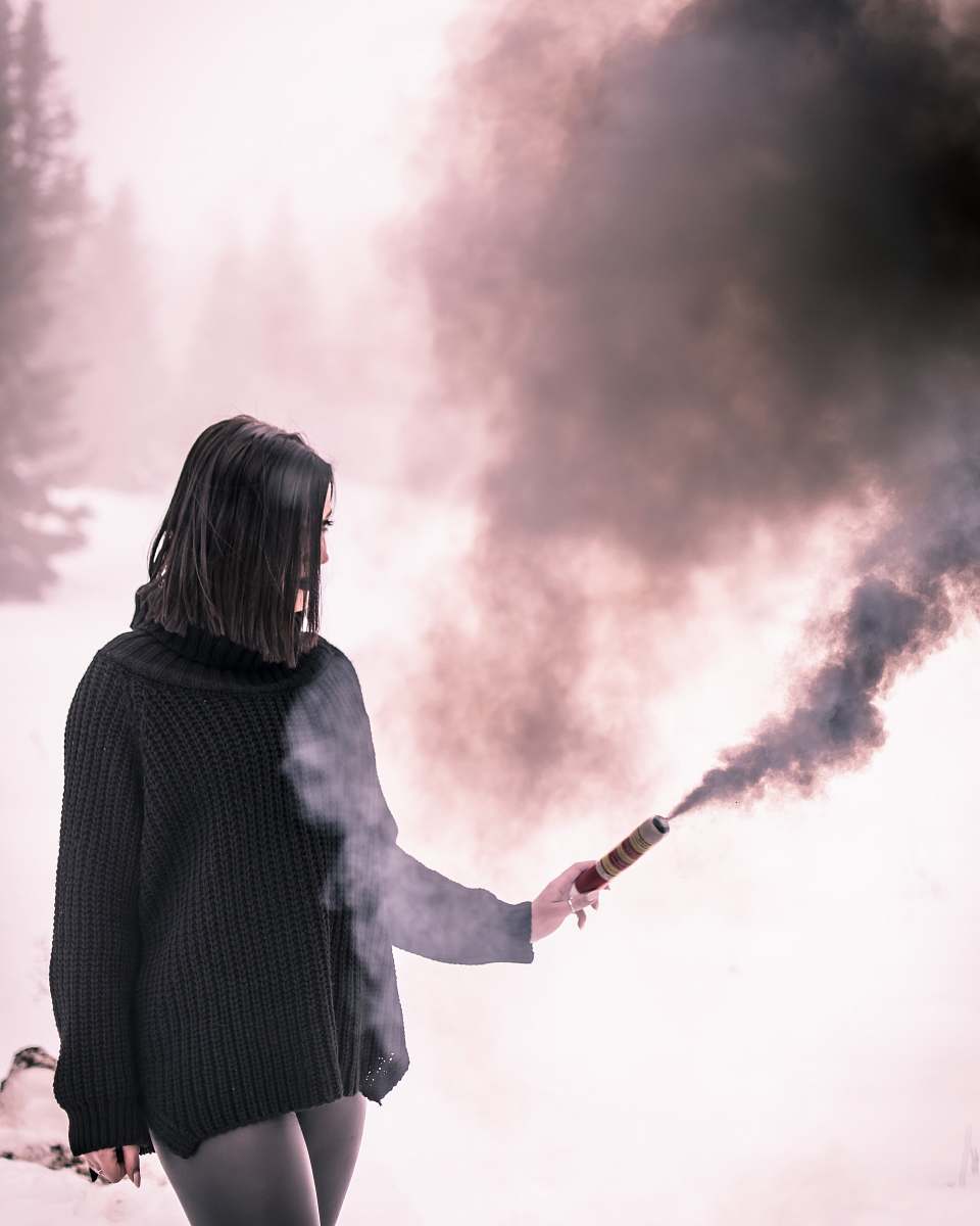 people woman in black knit long-sleeved shirt using black stick with smoke person