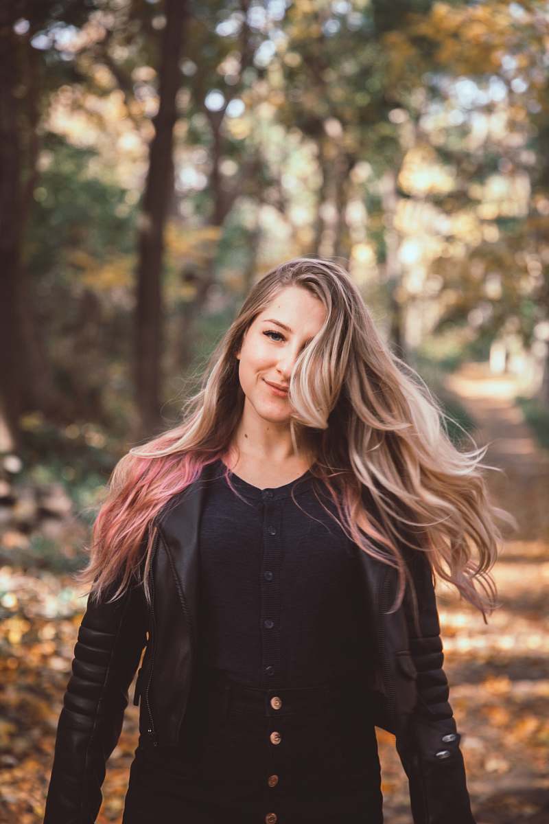 female woman in black leather jacket on forest woman