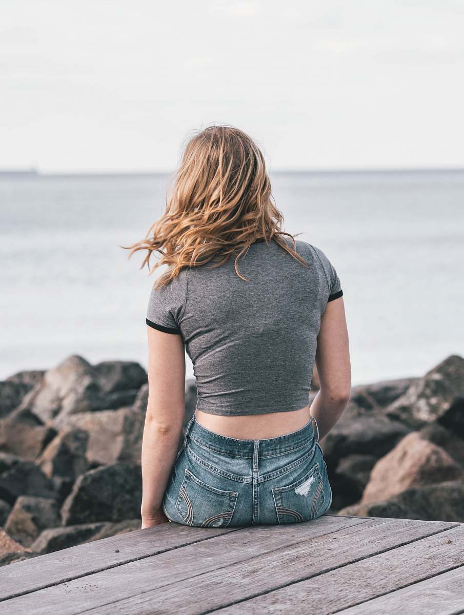 person woman in gray top sitting on dock people