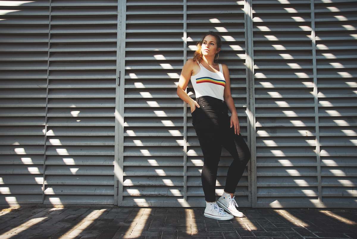 people woman in white tank top leaning on wall person